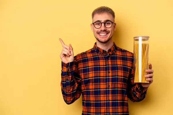 Young Caucasian Man Holding Spaghettis Jar Isolated Yellow Background Smiling — Stock fotografie