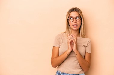 Kafkasyalı genç bir kadın, bej arka planda izole edilmiş, bir plan hazırlıyor..