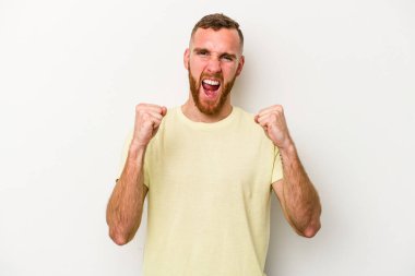 Beyaz arka planda izole edilmiş genç beyaz adam tasasız ve heyecanlı bir şekilde tezahürat yapıyor. Zafer konsepti.