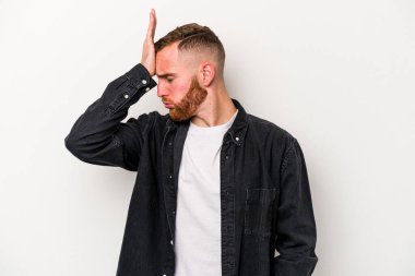 Beyaz arka planda izole edilmiş genç beyaz bir adam bir şeyi unutuyor. Alnına avuç içi ve gözlerini kapayarak vuruyor..