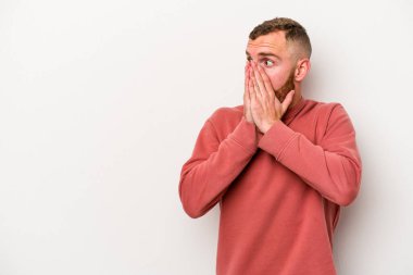 Beyaz arka planda izole edilmiş beyaz tenli genç adam ağzını eliyle kapatan bir fotokopi odasına bakıyor..