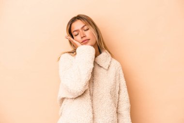 Bej arka planda izole edilmiş beyaz bir kadın. Sıkılmış, yorgun ve dinlenmeye ihtiyacı var..