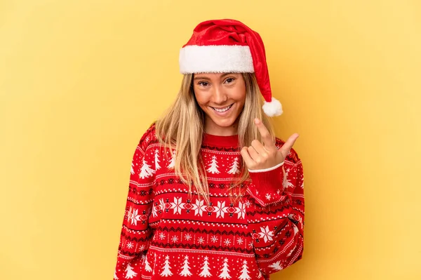若いですCaucasian女性祝いますクリスマス島で黄色の背景指す上に指であなたを招待するかのように近づく — ストック写真