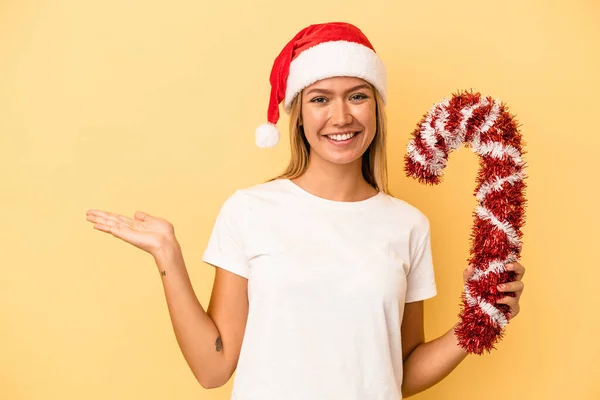 Sarı Arka Planda Izole Edilmiş Büyük Bir Noel Sopası Tutan — Stok fotoğraf