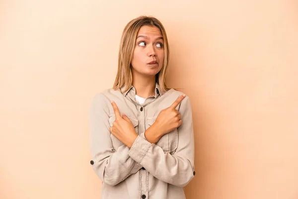 Jonge Blanke Vrouw Geïsoleerd Beige Achtergrond Punten Zijwaarts Probeert Kiezen — Stockfoto