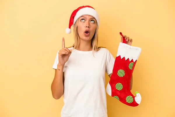 Mladá Běloška Drží Elfí Ponožku Izolovanou Žlutém Pozadí Ukazující Vzhůru — Stock fotografie