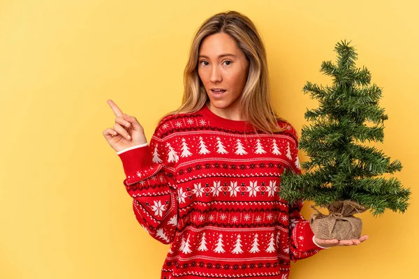 Junge Kaukasische Frau Mit Einem Kleinen Weihnachtsbaum Auf Gelbem Hintergrund — Stockfoto