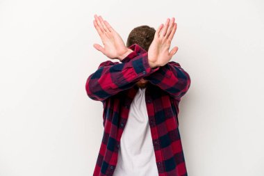 Beyaz arka planda izole genç beyaz adam iki kolu çapraz tutuyor, inkar kavramı.