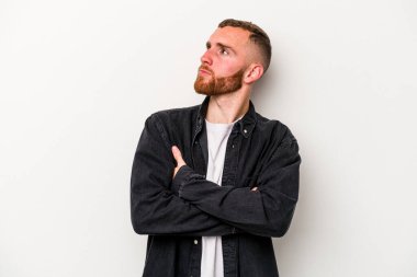 Beyaz arka planda izole edilmiş genç beyaz adam hedeflere ve amaçlara ulaşmayı hayal ediyor.