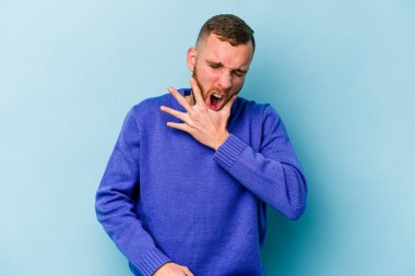 Mavi arka planda izole genç beyaz adam güçlü bir diş ağrısı, azıdişi ağrısı var..