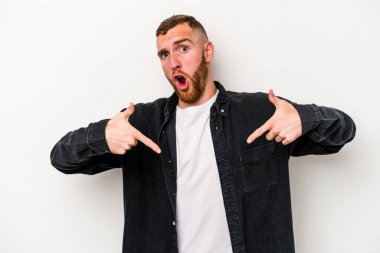 Beyaz arka planda izole edilmiş genç beyaz bir adam parmakları aşağıda, olumlu bir his var..