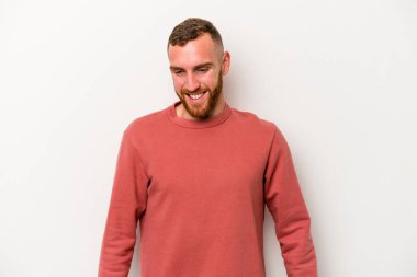 Beyaz arka planda izole edilmiş genç beyaz adam gülüyor ve gözlerini kapıyor, rahatlamış ve mutlu hissediyor..