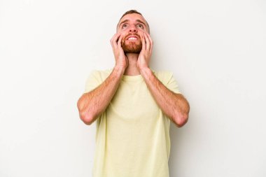 Beyaz arka planda ağlayan ve sızlanan beyaz tenli genç bir adam var..