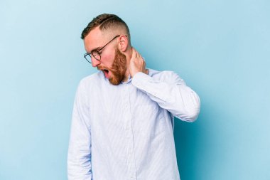 Kafkasyalı genç bir adam mavi arka planda izole edilmiş. Durağan yaşam tarzından dolayı boyun ağrısı çekiyor..