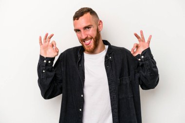 Beyaz arka planda izole edilmiş genç beyaz bir adam neşeli ve kendinden emin..