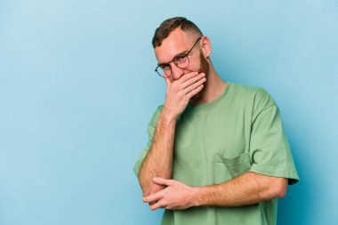 Kafkasyalı genç adam mavi arka planda yalnızdı gülerek, kaygısızca, doğal duygularla.