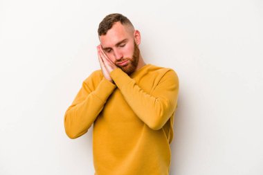 Beyaz arka planda izole edilmiş genç beyaz adam esniyor. Ağzı eliyle kapatan yorgun bir hareket sergiliyor..