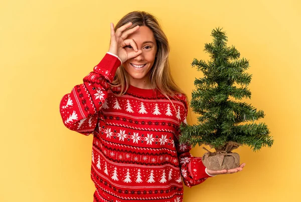Jovem Caucasiana Segurando Uma Pequena Árvore Natal Isolada Fundo Amarelo — Fotografia de Stock
