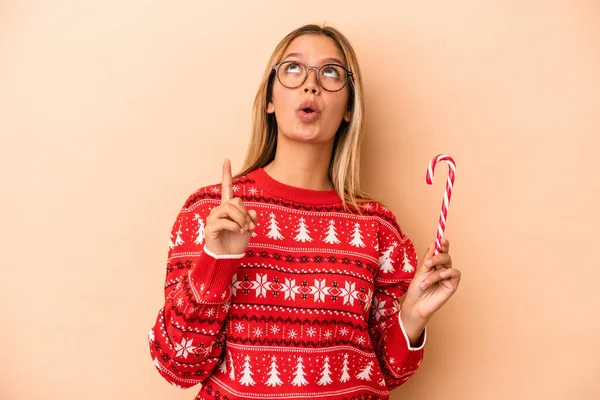 Young Caucasian Woman Holding Christmas Stick Isolated Beige Background Pointing — Stock fotografie