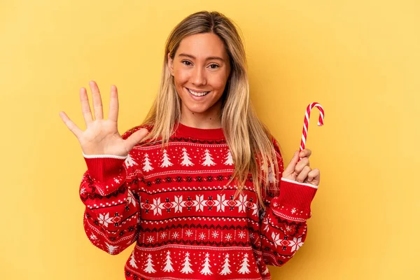 Young Caucasian Woman Holding Christmas Stick Isolated Yellow Background Smiling — Stock Photo, Image