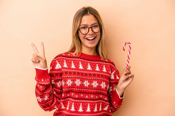 Young Caucasian Woman Holding Christmas Stick Isolated Beige Background Joyful — Stok fotoğraf