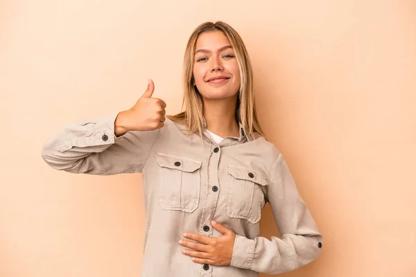 Mujer Joven Caucásica Aislada Sobre Fondo Beige Toca Barriga Sonríe —  Fotos de Stock