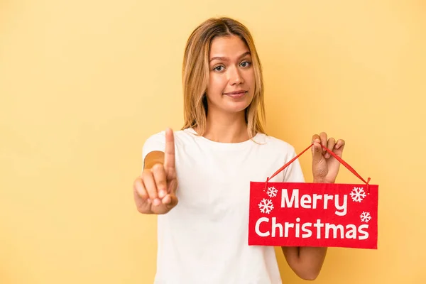 Mladá Běloška Drží Veselé Vánoční Plakát Izolované Žlutém Pozadí Ukazující — Stock fotografie