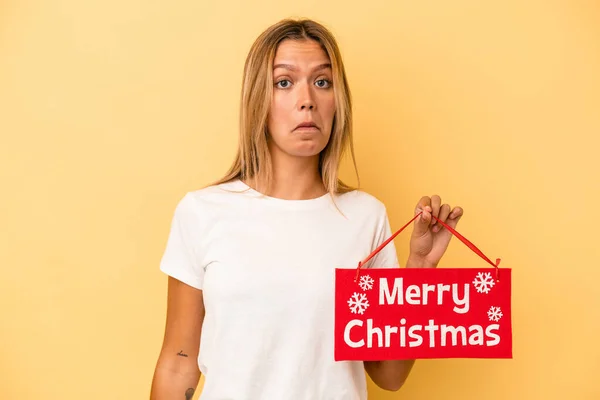 Mladá Běloška Drží Veselé Vánoční Plakát Izolované Žlutém Pozadí Pokrčí — Stock fotografie