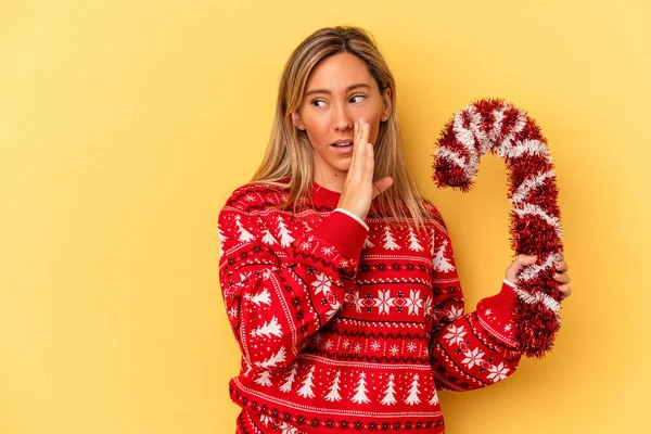 Young Caucasian Woman Holding Big Christmas Stick Isolated Yellow Background — Stock Photo, Image