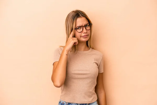 Joven Mujer Caucásica Aislada Sobre Fondo Beige Apuntando Templo Con —  Fotos de Stock