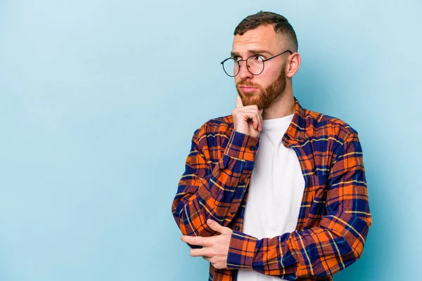 Young Caucasian Man Isolated Blue Background Looking Sideways Doubtful Skeptical — Stock Photo, Image