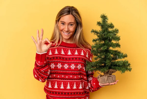 Mladá Běloška Žena Drží Malý Vánoční Stromek Izolované Žlutém Pozadí — Stock fotografie