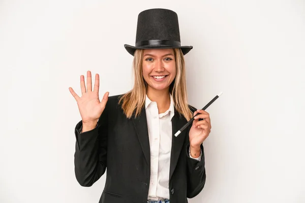 Young caucasian wizard woman holding wand isolated on white background smiling cheerful showing number five with fingers.