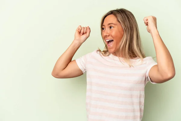 Junge Kaukasierin Isoliert Auf Grünem Hintergrund Hebt Nach Einem Sieg — Stockfoto