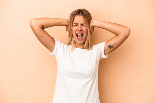 Mujer Caucásica Joven Aislada Sobre Fondo Beige Cubriendo Las Orejas —  Fotos de Stock