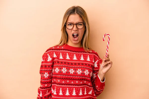 Young Caucasian Woman Holding Christmas Stick Isolated Beige Background Screaming — Stok fotoğraf
