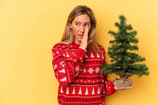 Jonge Blanke Vrouw Met Een Kleine Kerstboom Geïsoleerd Gele Achtergrond — Stockfoto