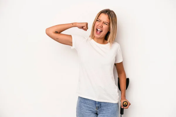 Young Caucasian Woman Holding Crutch Isolated White Background Raising Fist — Stok fotoğraf