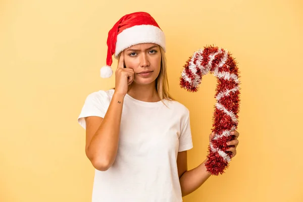 Mladá Běloška Drží Velkou Vánoční Hůl Izolované Žlutém Pozadí Ukazuje — Stock fotografie