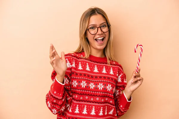 Young Caucasian Woman Holding Christmas Stick Isolated Beige Background Receiving — Stok fotoğraf