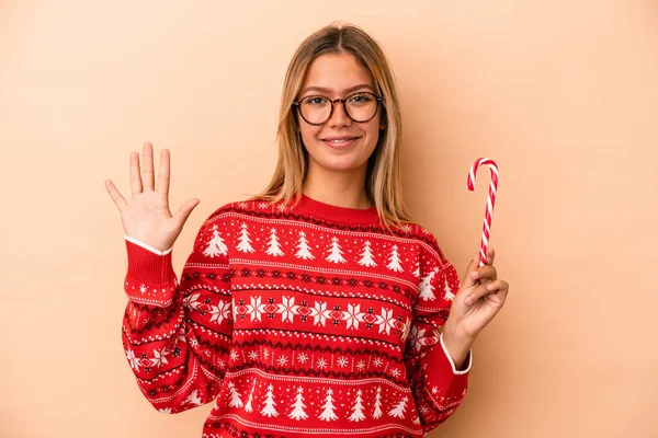 Young Caucasian Woman Holding Christmas Stick Isolated Beige Background Smiling — Stock fotografie