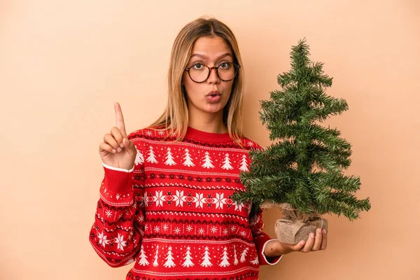 Young Caucasian Woman Holding Little Christmas Tree Isolated Beige Background — Stok fotoğraf