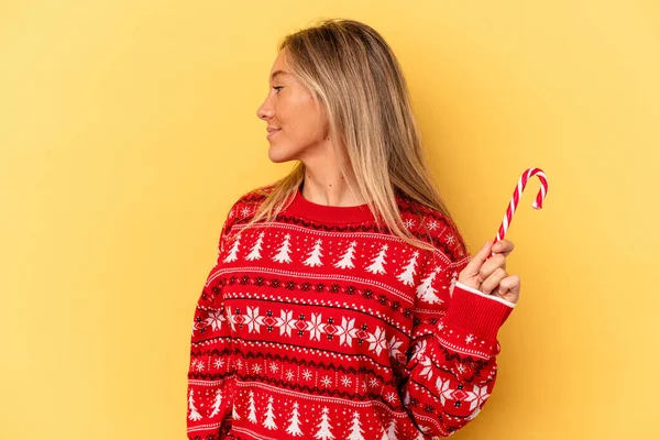 Jonge Blanke Vrouw Met Een Kerststokje Geïsoleerd Gele Achtergrond Kijkt — Stockfoto