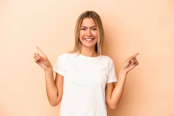 Mujer Caucásica Joven Aislada Sobre Fondo Beige Apuntando Diferentes Espacios —  Fotos de Stock