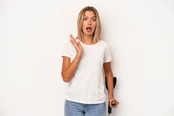 Young Caucasian Woman Holding Crutch Isolated White Background Surprised Shocked — Stock Photo, Image