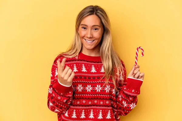 Jovem Caucasiana Segurando Uma Vara Natal Isolada Fundo Amarelo Apontando — Fotografia de Stock