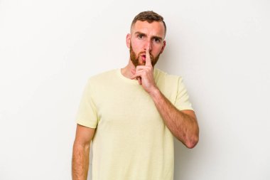 Beyaz arka planda izole edilmiş genç beyaz bir adam ya sır saklıyor ya da sessizlik istiyor..