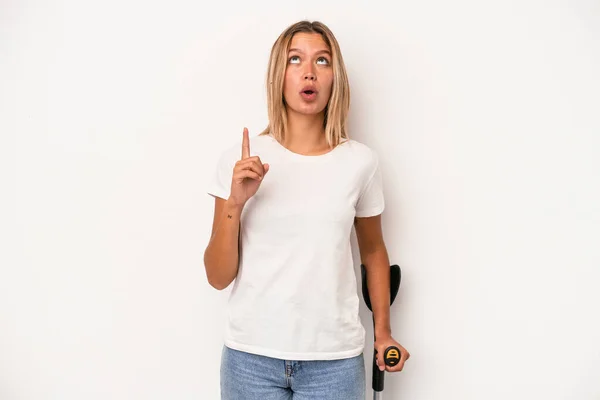 Young Caucasian Woman Holding Crutch Isolated White Background Pointing Upside — ストック写真
