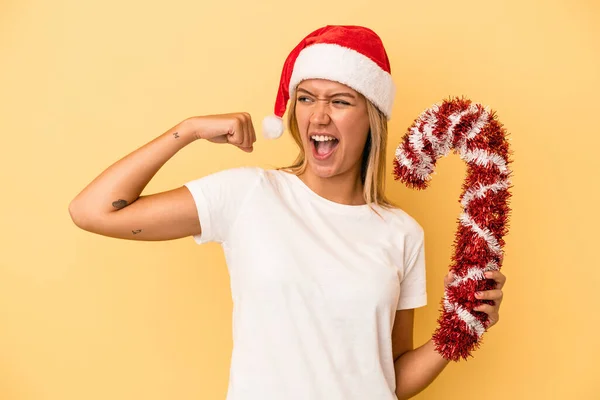 Young Caucasian Woman Holding Big Christmas Stick Isolated Yellow Background — Stock Photo, Image