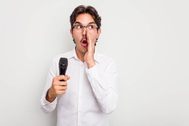 Beyaz arka planda izole edilmiş genç İspanyol şarkıcı gizli bir sıcak fren haberi veriyor ve yana bakıyor.